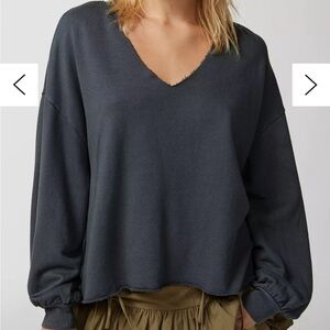 Out from under roomy black sweatshirt top